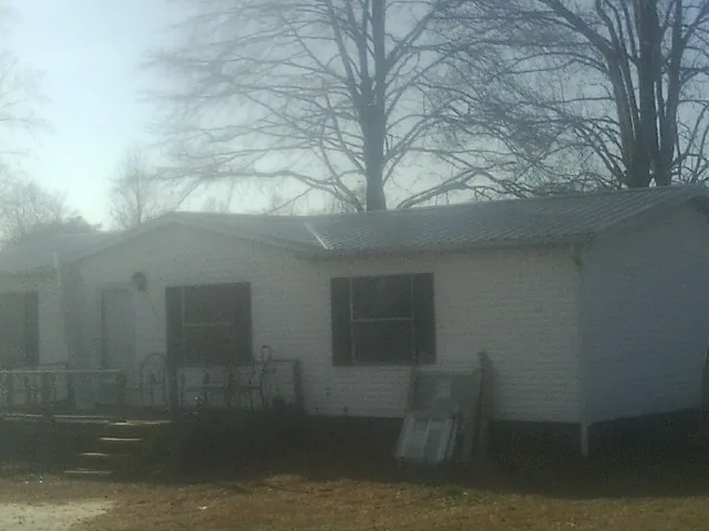 New metal roof on a white painted brick home on a foggy morning in Bridge City