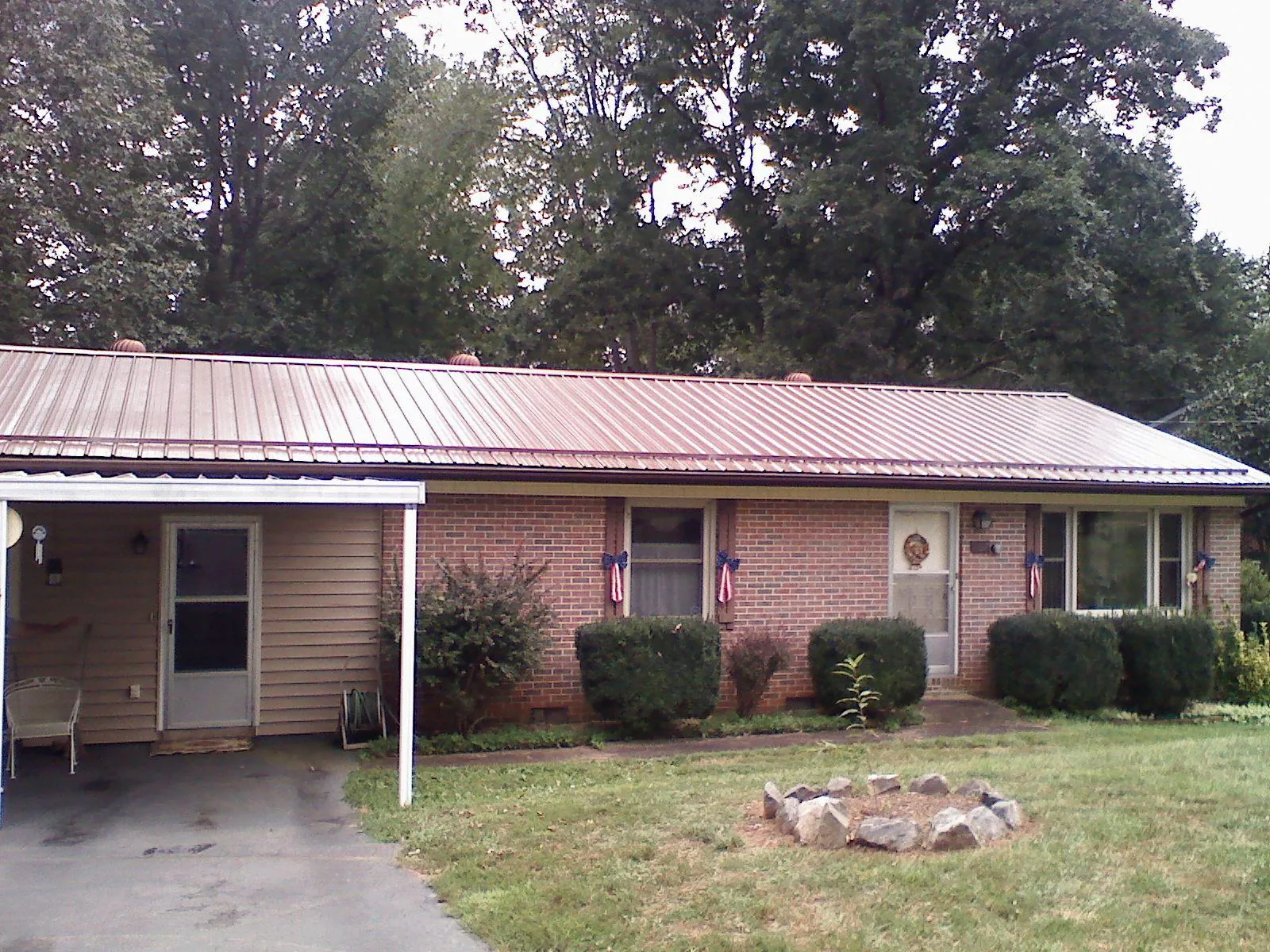 Bronze metal roof and carport on a brick ranch home — Roof Repair work by our crew in Bridge City